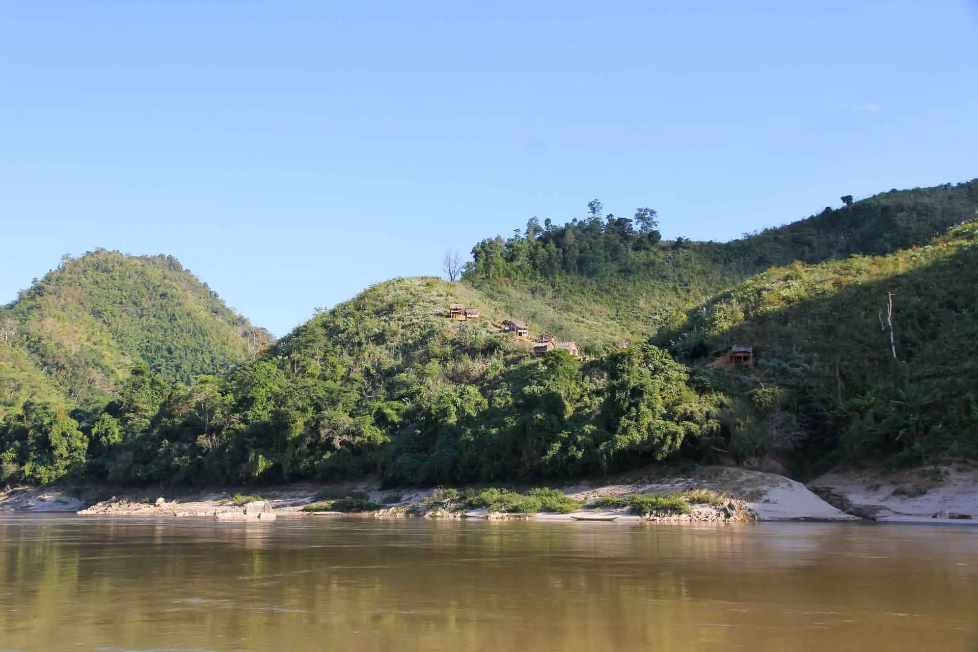 Village on a green hillside along the Mekong River