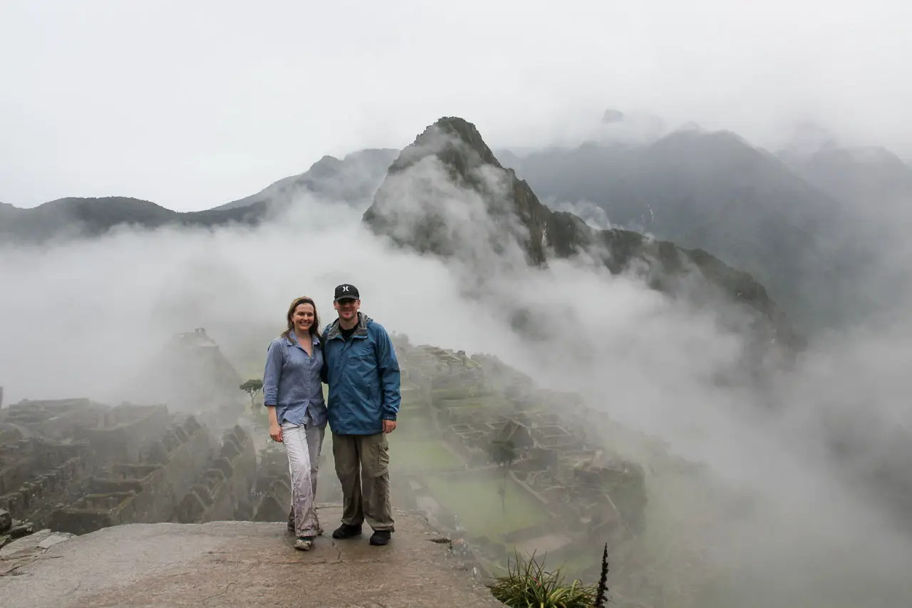 Couple standing infront of misty mountain scenery and archaeological site
