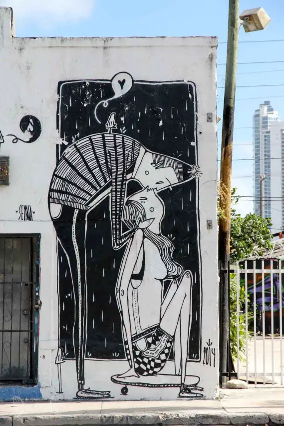 Black and white street art mural of couple kissing