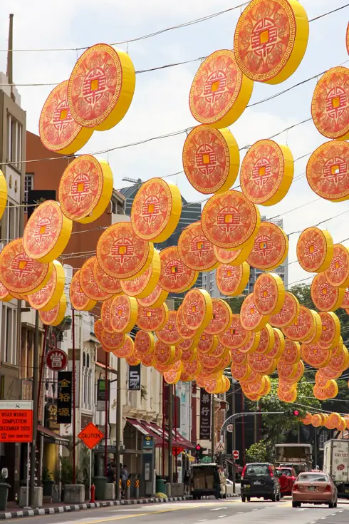 Coin-shaped lanterns hanging across a street in Chinatown, Singapore