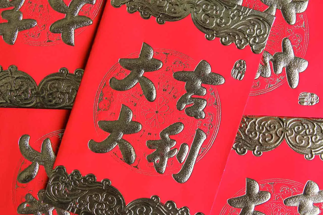 Close up of red envelopes with gold decoration and Chinese text