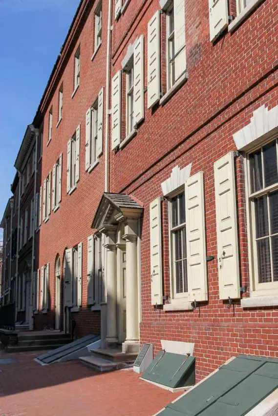 Photo of historic, red brick town homes with cream shutters