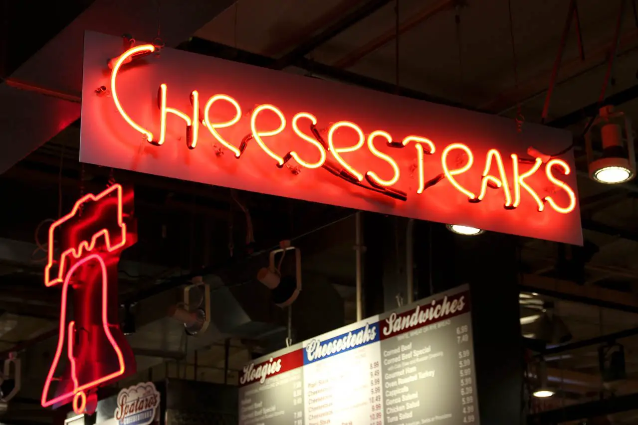 Neon sign reading "cheesesteaks" and another in the shape of the Liberty Bell