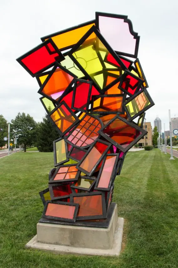 Outdoor sculpture made of coloured glass panels in red, orange, pink and yellow.