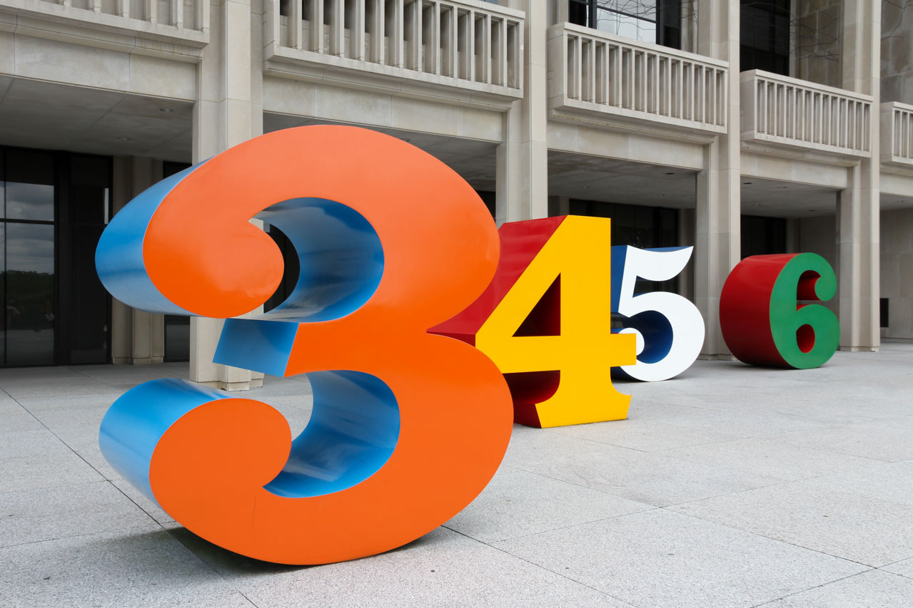 Oversided, bold-coloured, three-dimensional numbers in front of museum.