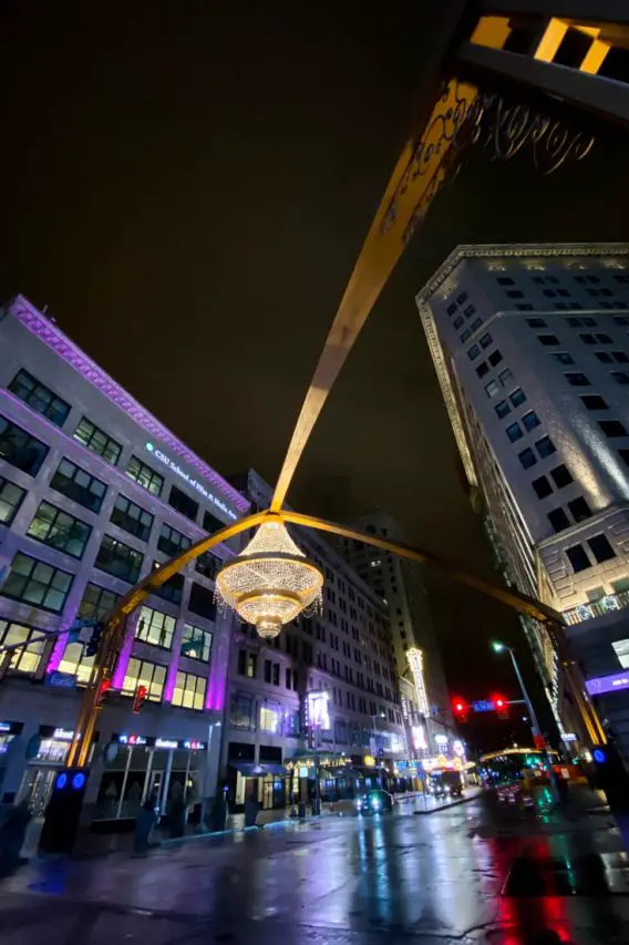 Photo of giant outdoor chandelier over street lined in theaters