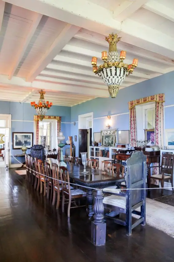 Large dining room with antique furniture and large chandeliers.