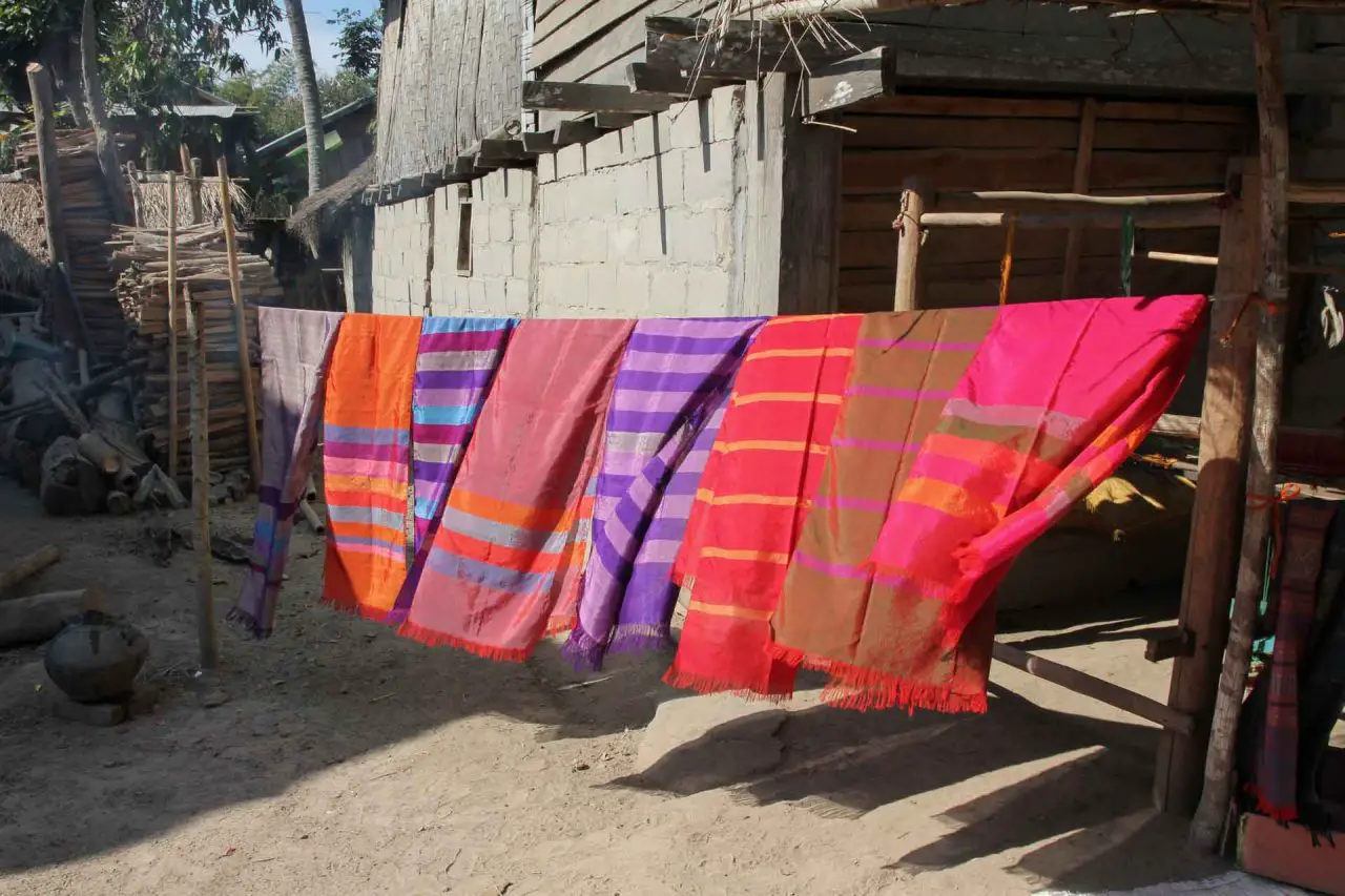 Brightly coloured silk scarves hanging in a rural village