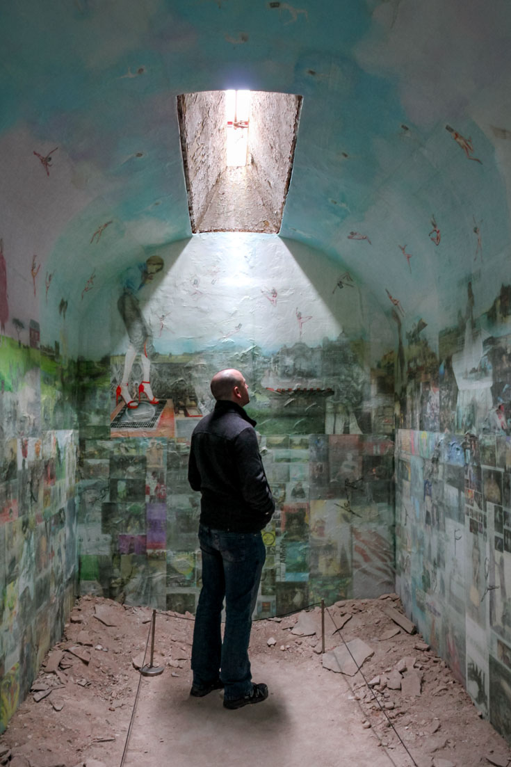 Man looking at art installation inside a penitentiary cell