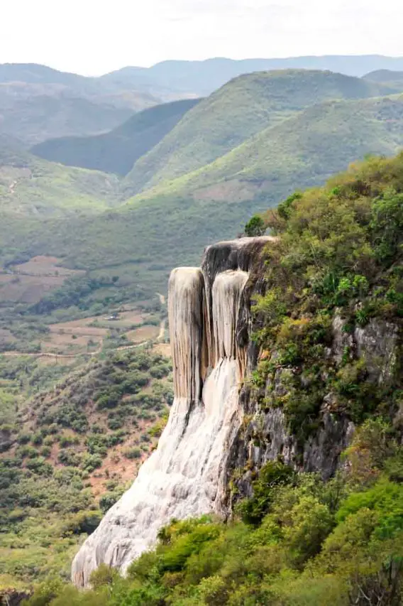 A petrified watefall with mountains in the background