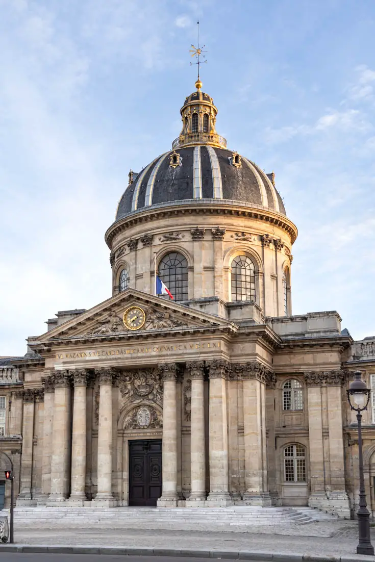 The Baroque exterior of the Institut de France with golden sunlight on the dome