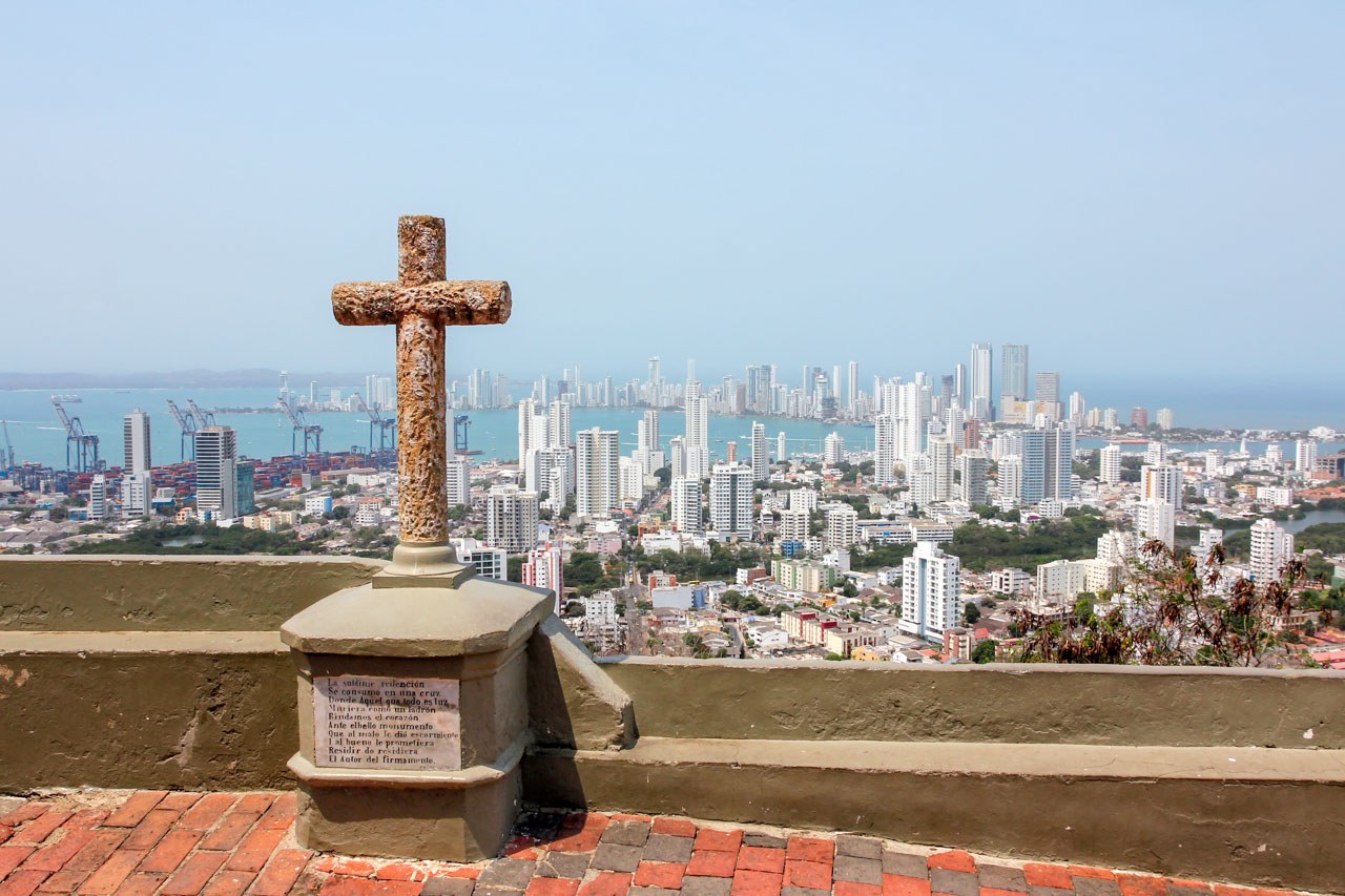 Panoramic view of city below with cross in foreground
