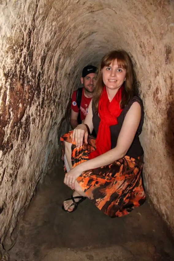 Woman and man crouched down inside tunnel
