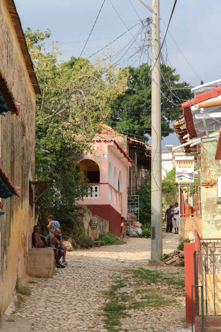 Cobblestone path leads up a hill, lined with colourful homes