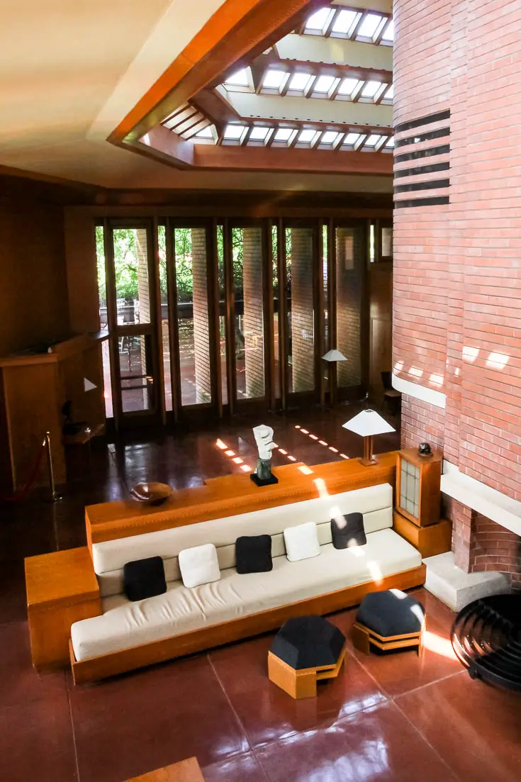Wingspread lounge and dining space in red brick, viewed from mezzanine above