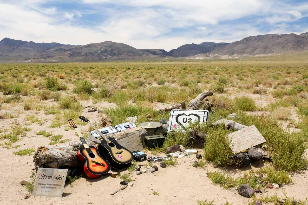 Fallen tree with fan tributes including guitars and roadcases