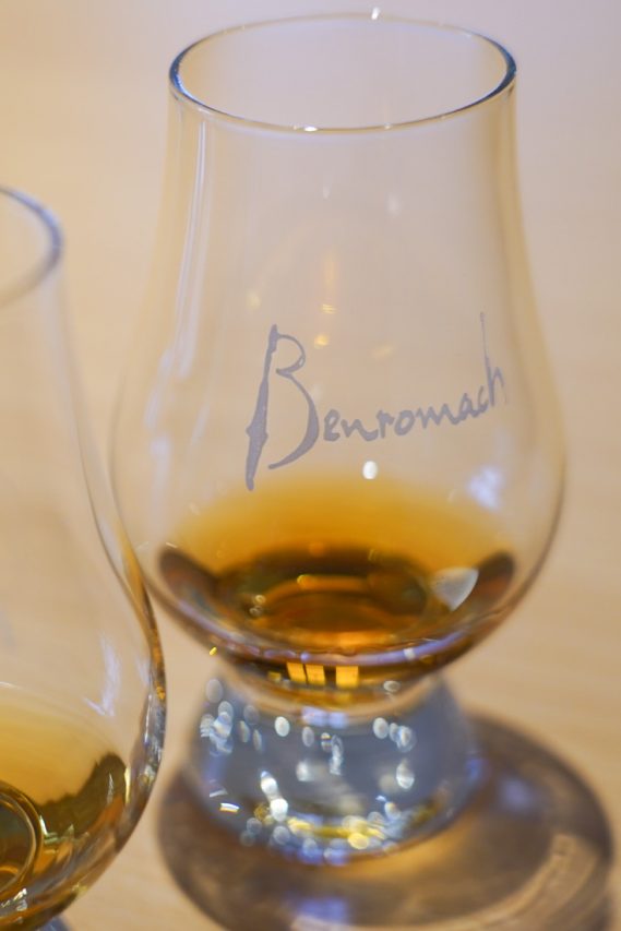Whisky glass with Benromach logo, containing a wee dram.