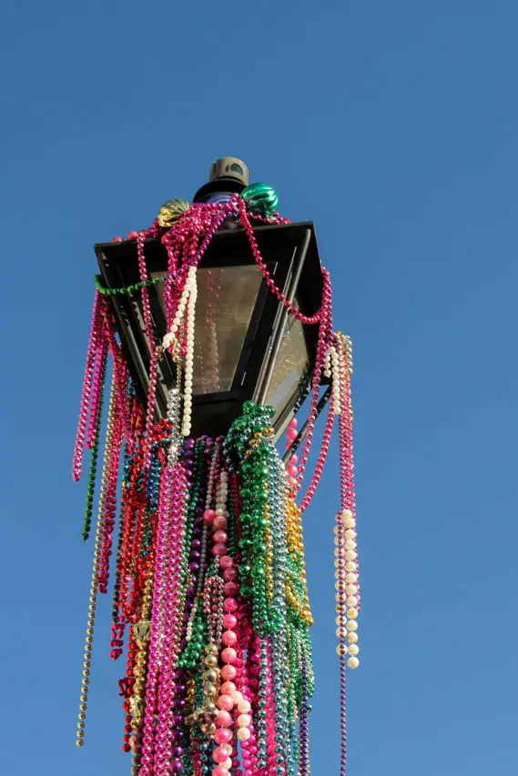 Lamp post strung with coloured beads against a blue sky.