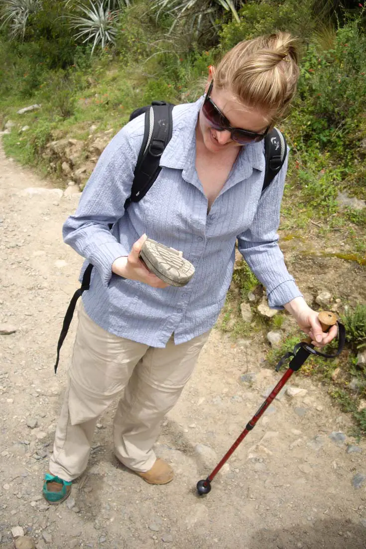 Woman holding sole of broken shoe on Inca Trail