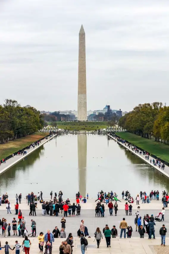 Photo of people taking pictures of the Washington Monument reflected in the Lincoln Memorial Reflecting Pool