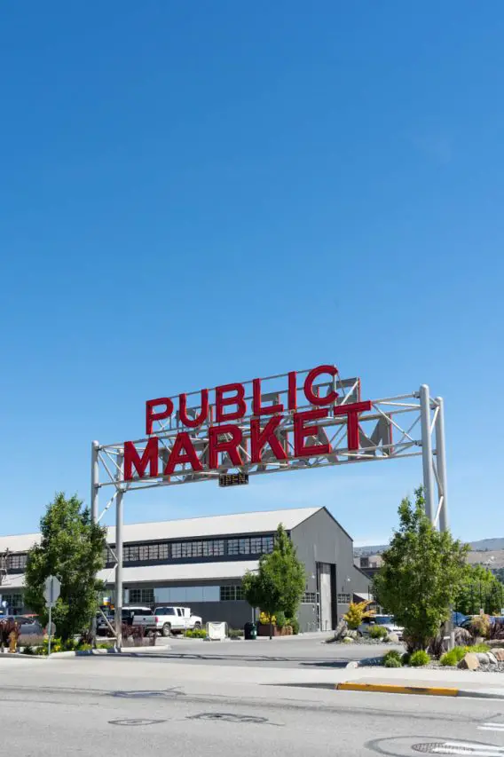 Photo of red sign reading "Public Market" with large grey shed.