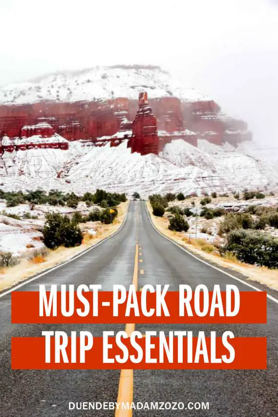 Photo of road leading to red rock formation covered in snow, with a text overlay reading "Must-Pack Road Trip Essentials"