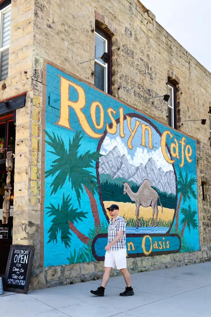 Man walking past Roslyn Cafe mural