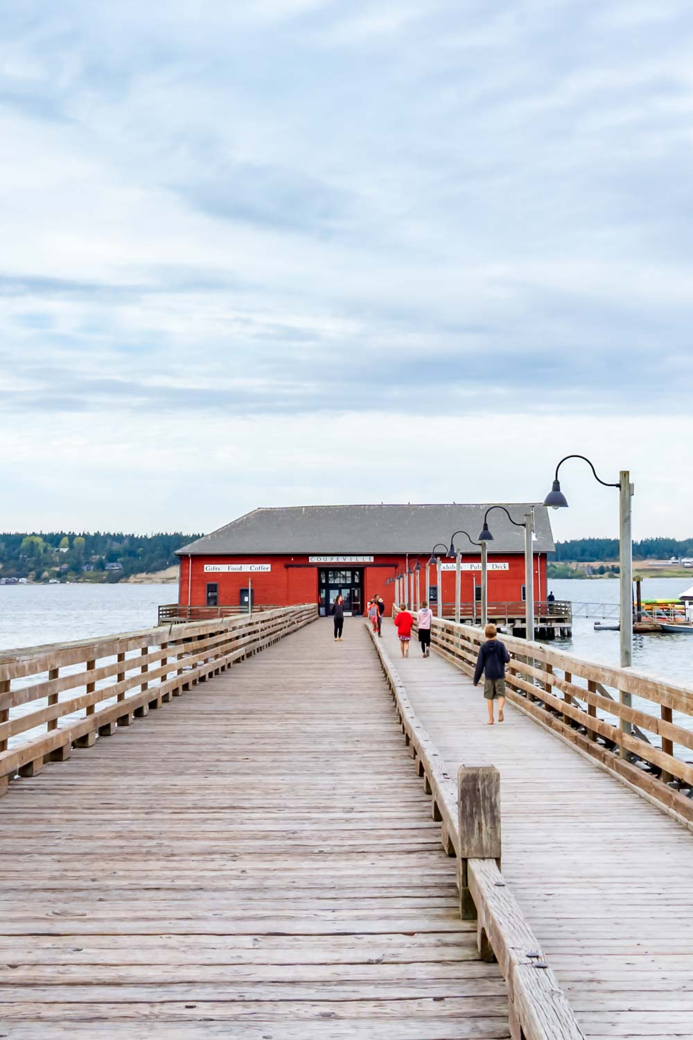 Wooden wharf with bright red building at the end on a cloudy day