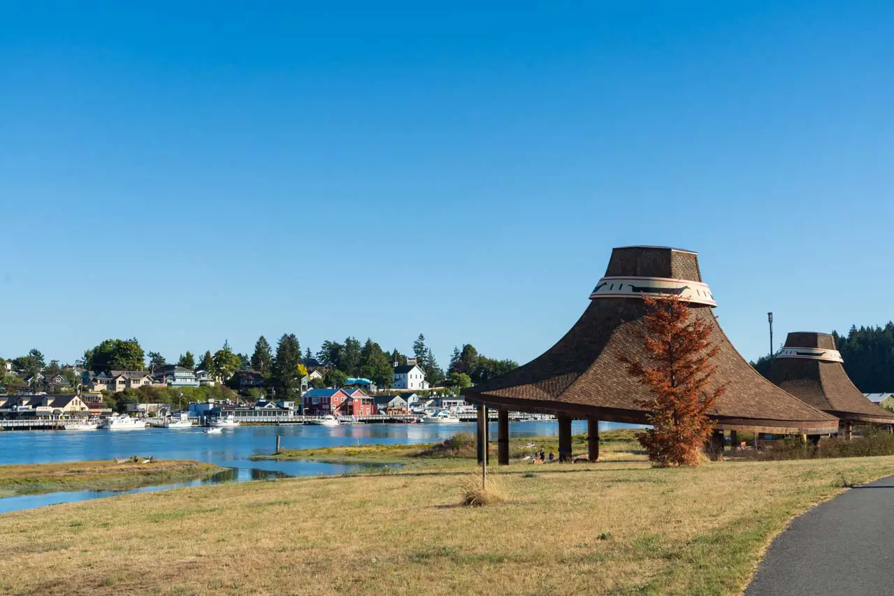 Conical shaped pavilions with flat tops in foreground of river and waterfront historic buildings