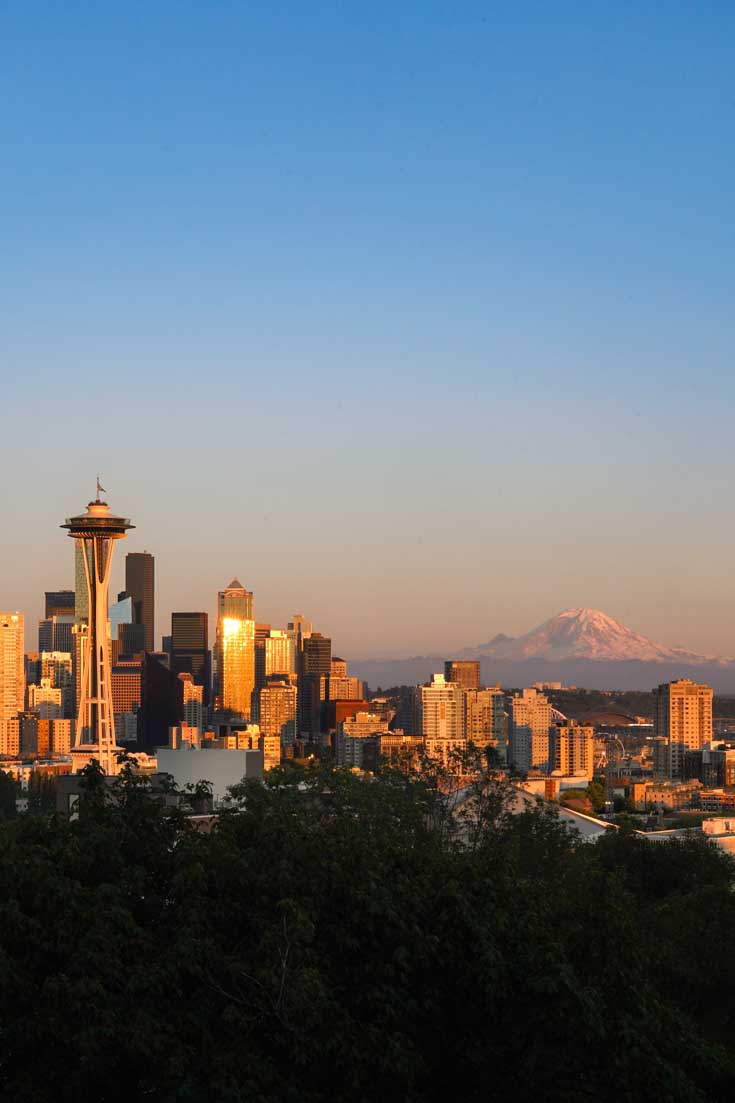 View of Seattle cityscape at near sunsest with blue sky and golden light on buildings