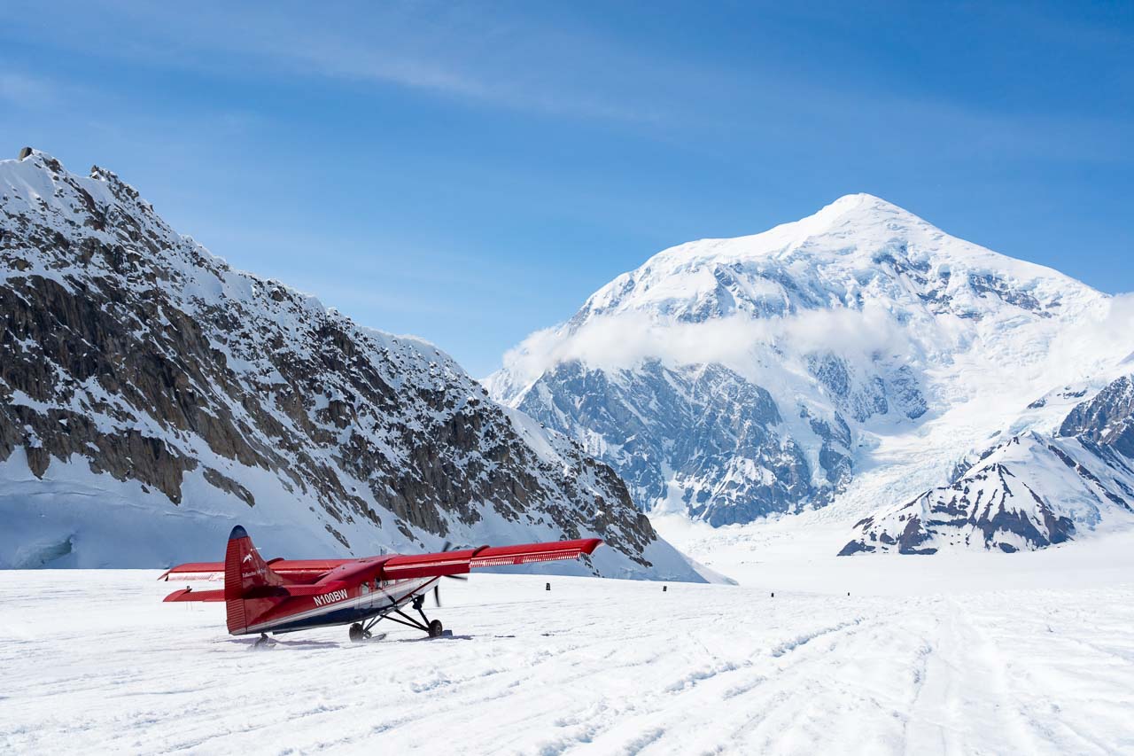 Flightseeing plane landed on glacier with mountain peak in the distance