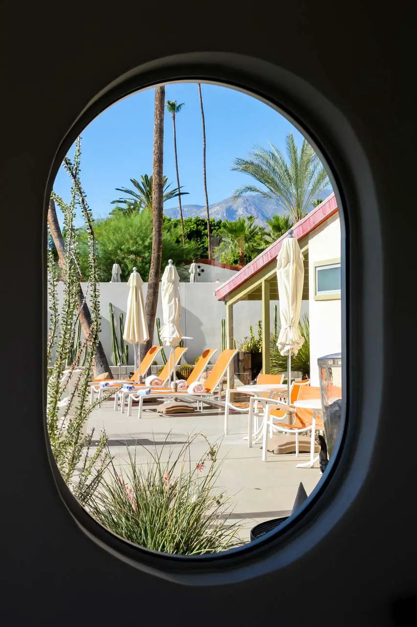 View of orange deck chairs through a rounded window