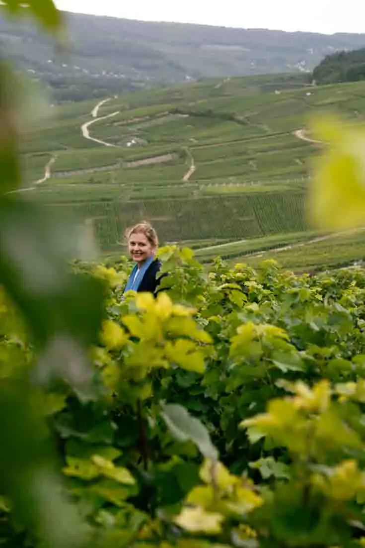 Woman standing in vineyards that stretch into the distance