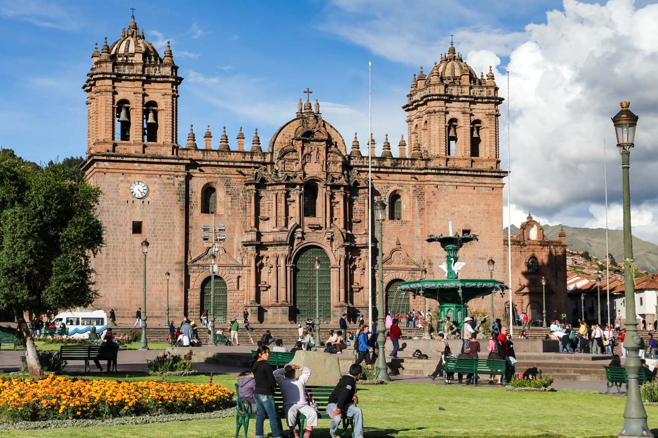 Front facade of the Cathedral Basilica of the Virgin of the Assumption on a sunny afternoon with people in the town square infront