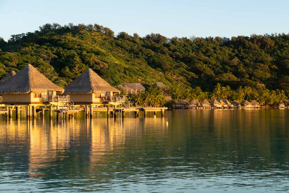 Overwater bungalows glowing in golden hour light