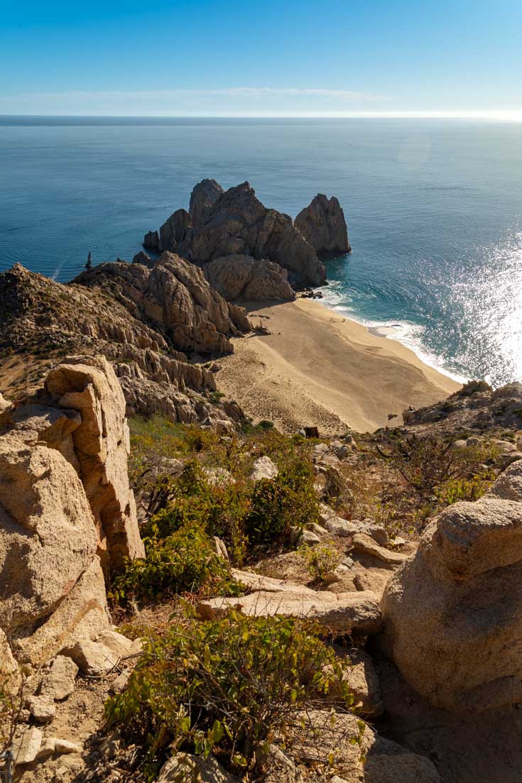 Rocky headland and sandy beach, viewed from overlook above