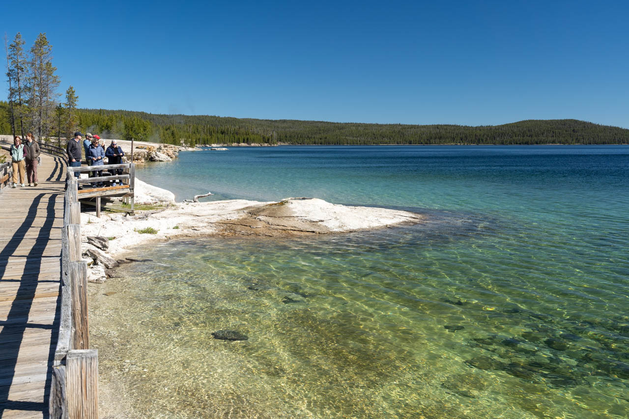 Geyser on the shores of Lake Yellowstone with boardwalk running along side