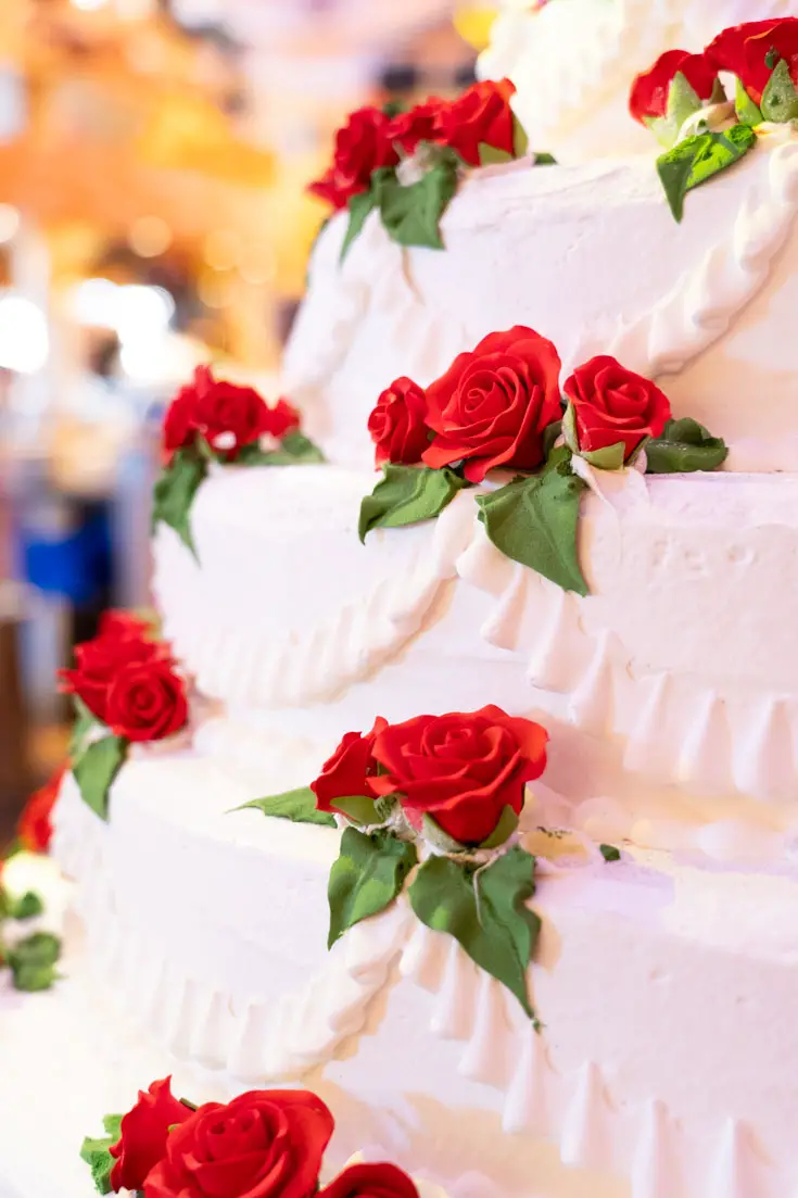Close up for tiered cake decorated with red roses