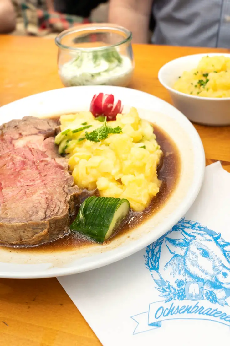 Plate of ox prime rib with potato salad and cucumber side dishes