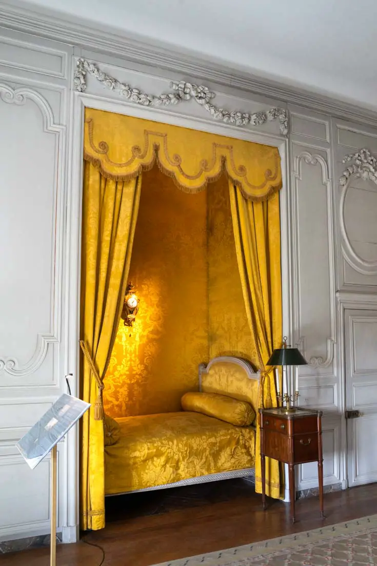 Daffodil yellow bed recessed into a curtained niche 