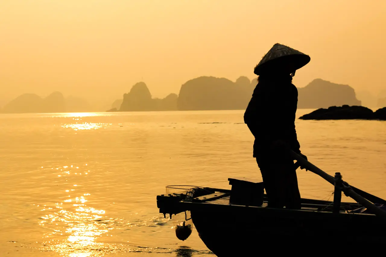 Silhouette of a Ha Long Bay fisherman at in golden hour light
