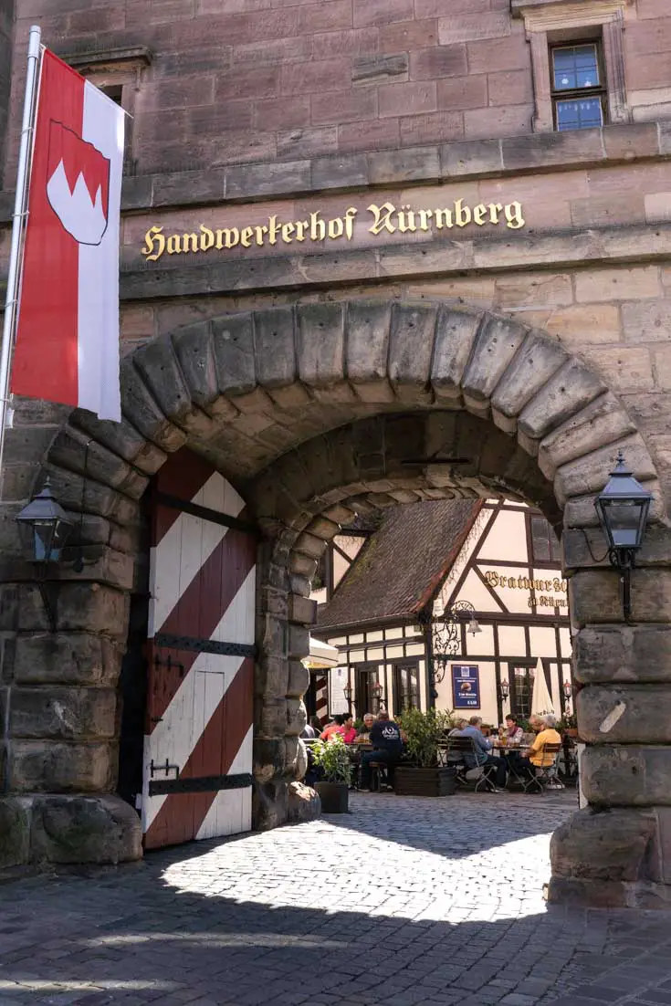 Arched entrance to the Craftmen's Courtyard with half-timbered architecture visible through opening
