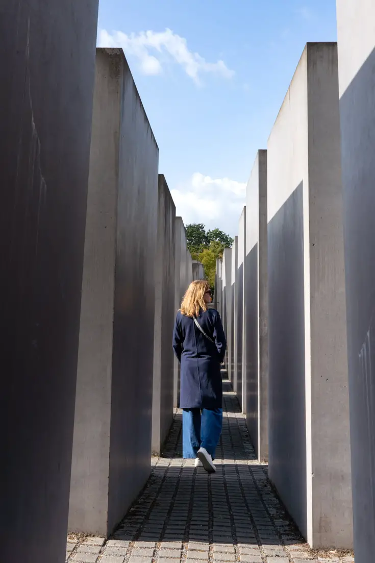 Woman walking through the concrete stelae of the Memorial to the Murdered Jews