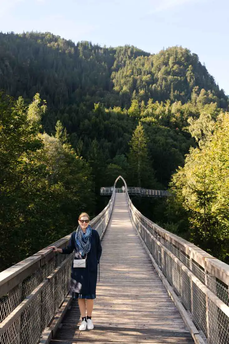 Woman standing on boardwalk in mountains