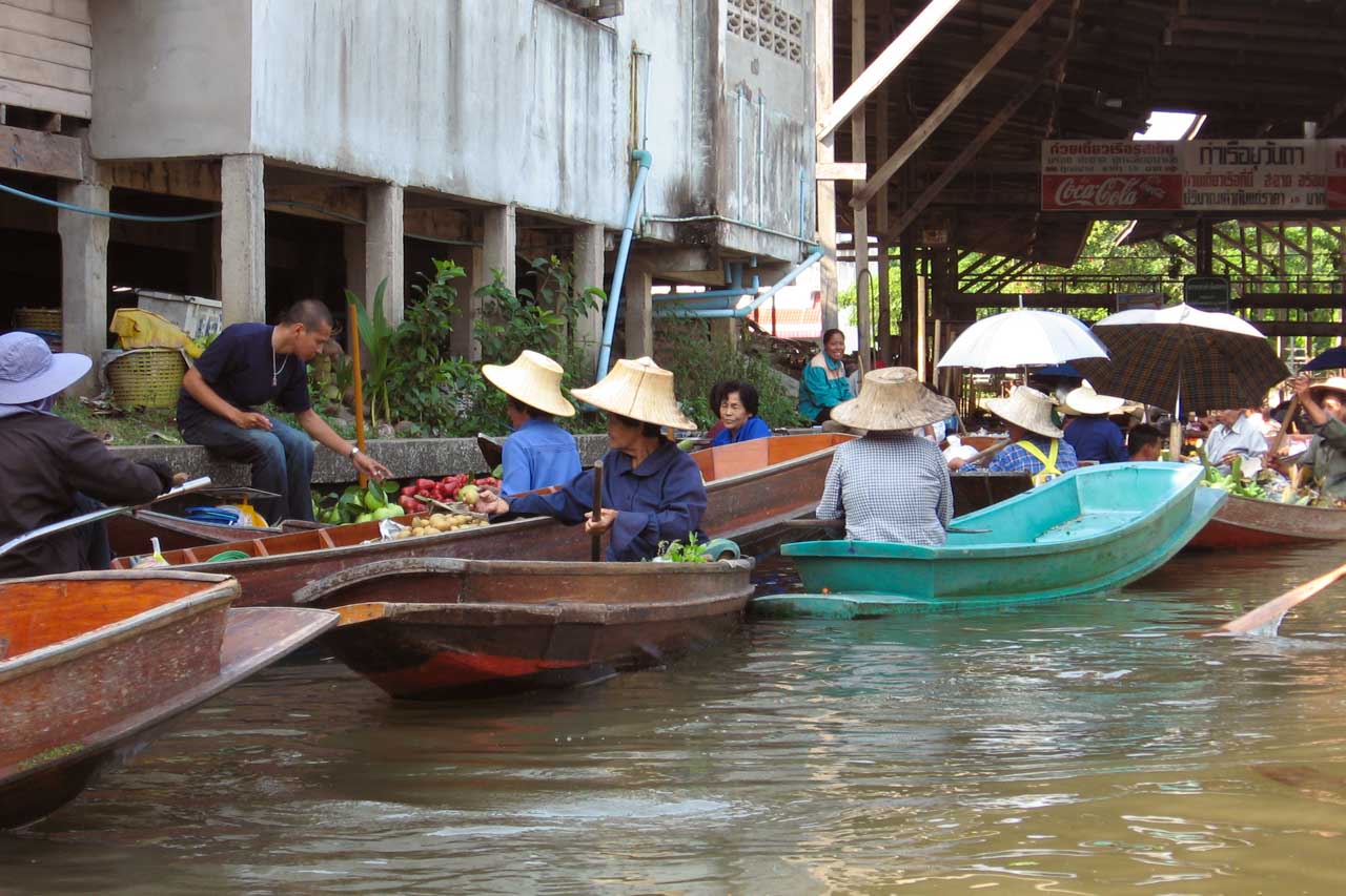 Vendors selling fresh produce from boats at a floating market