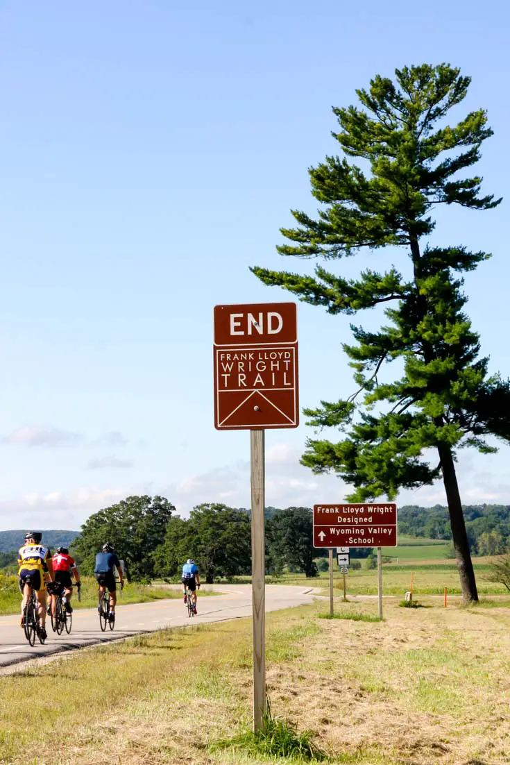 Frank Lloyd Wright "End Trail" sign outside Taliesin with cyclists on road in background