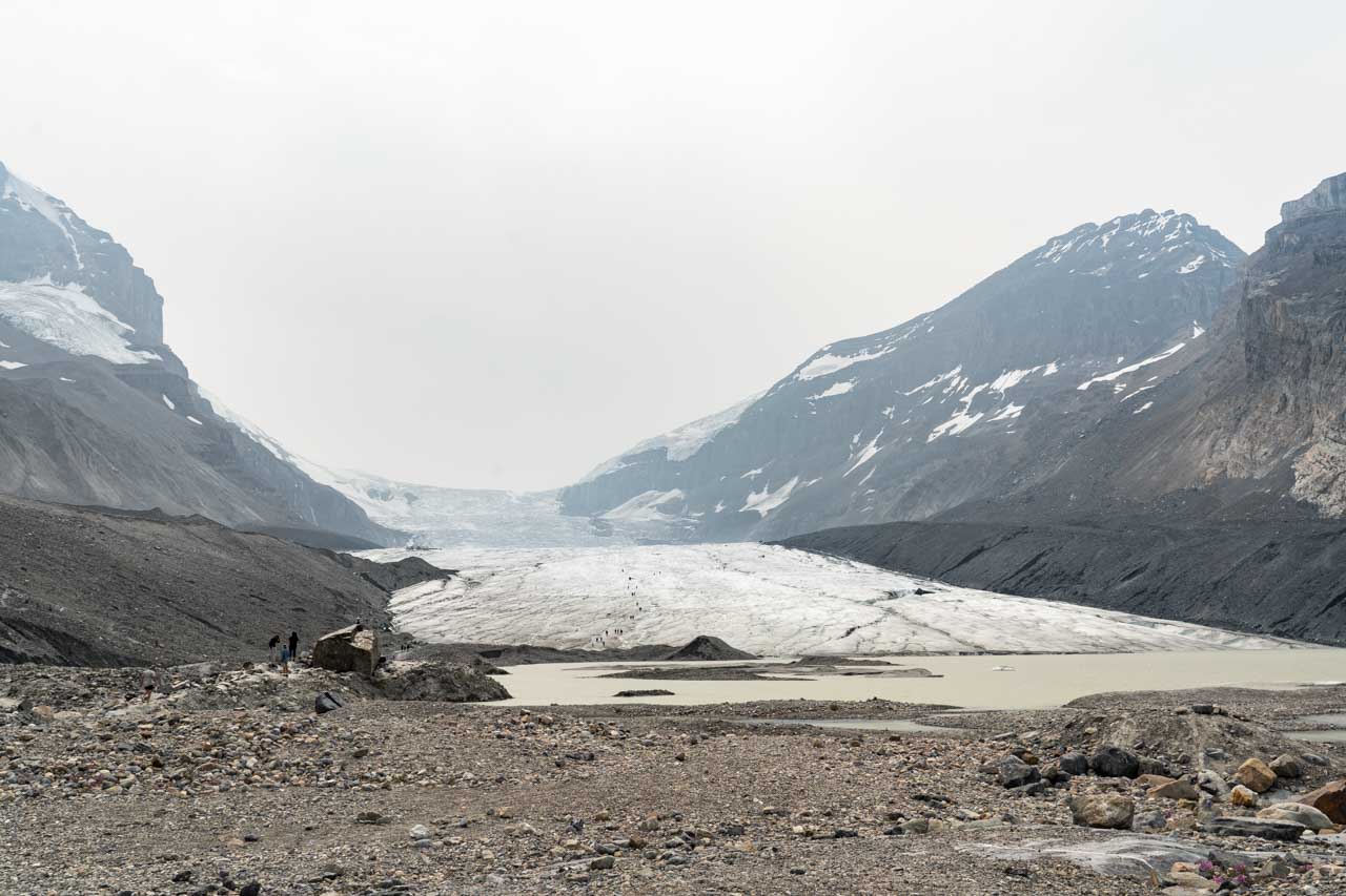 The toe of Athabasca Glacier with people walking on ice