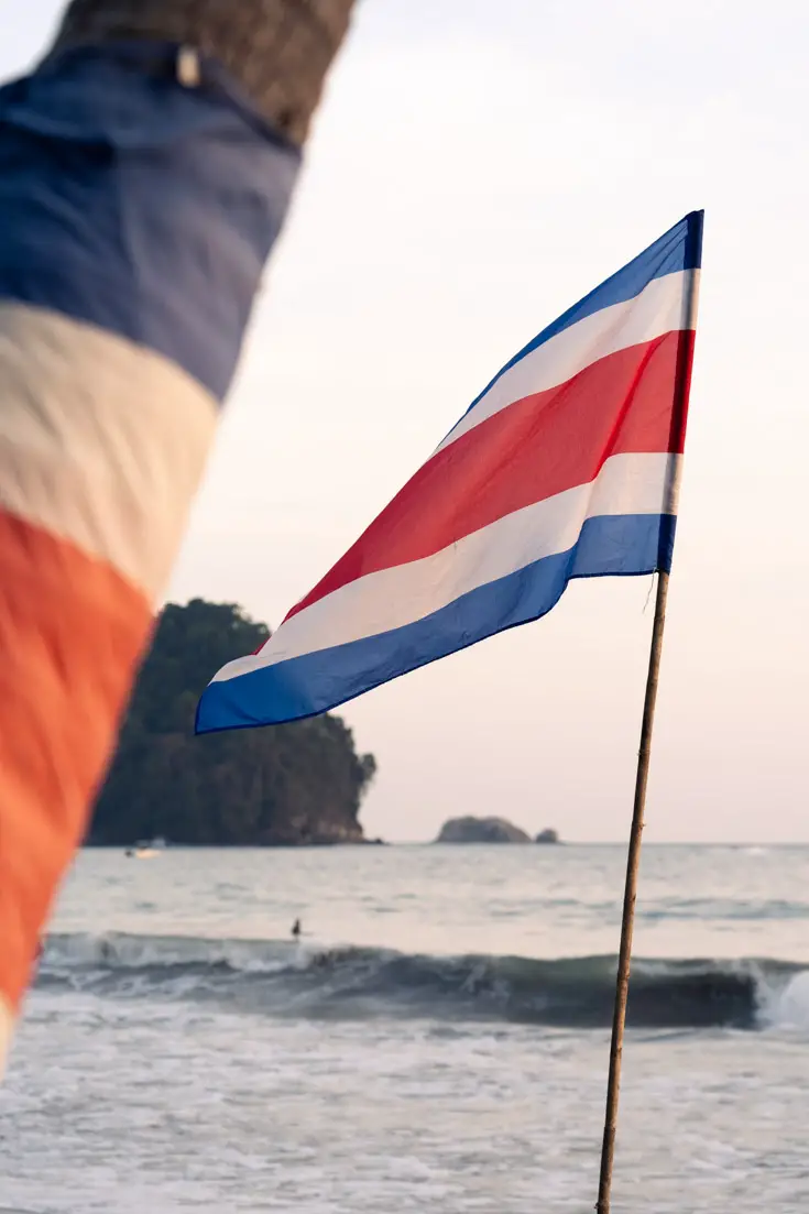 Costa Rican national flag flying at sunset on a beach