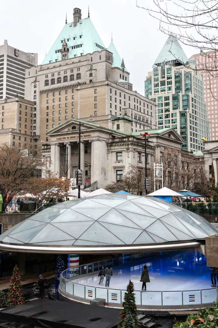 Dome-covered ice rink backed by city buildings