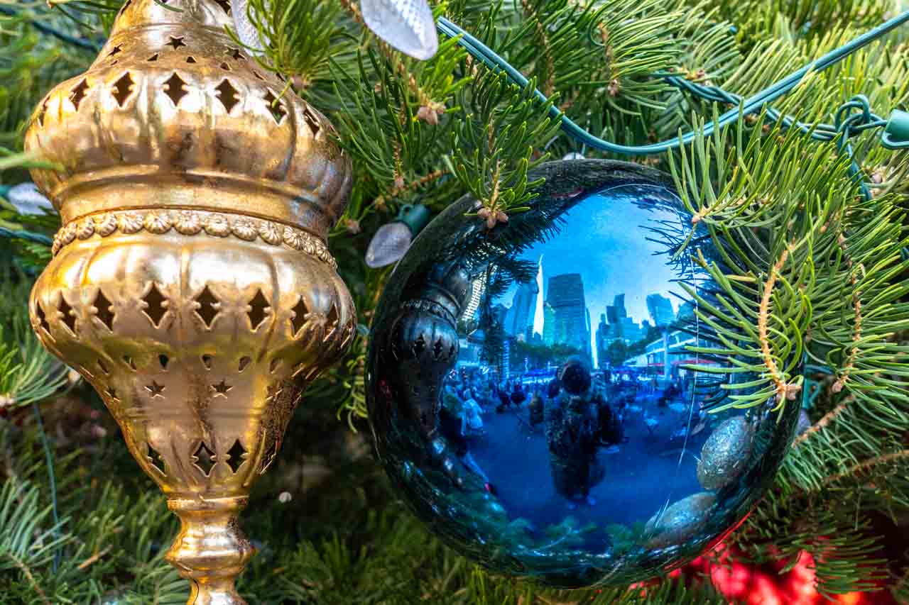 Woman taking photo of her reflection in a blue Christmas bauble